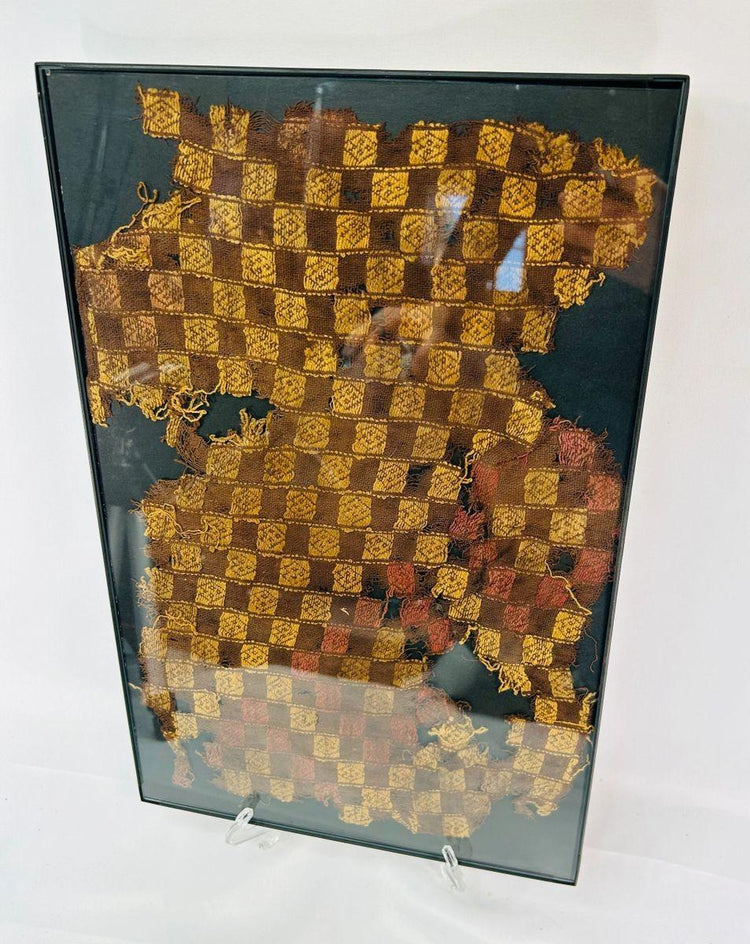 Detailed view of Andean textile fragment featuring yellow, brown, and red woven squares.