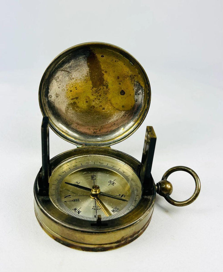 Museum-style photograph of a French pocket compass used as an early 20th-century navigation instrument.