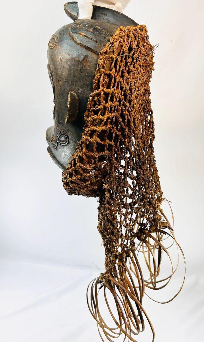 Antique Central African Chokwe mask with closed eyes and decorative fibers