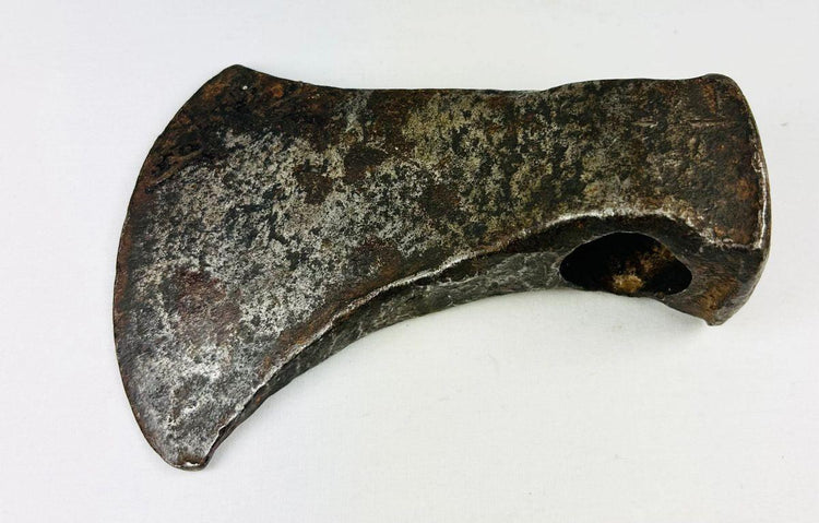 Forged iron axe head used by early settlers, showing authentic patina and handcrafted construction.