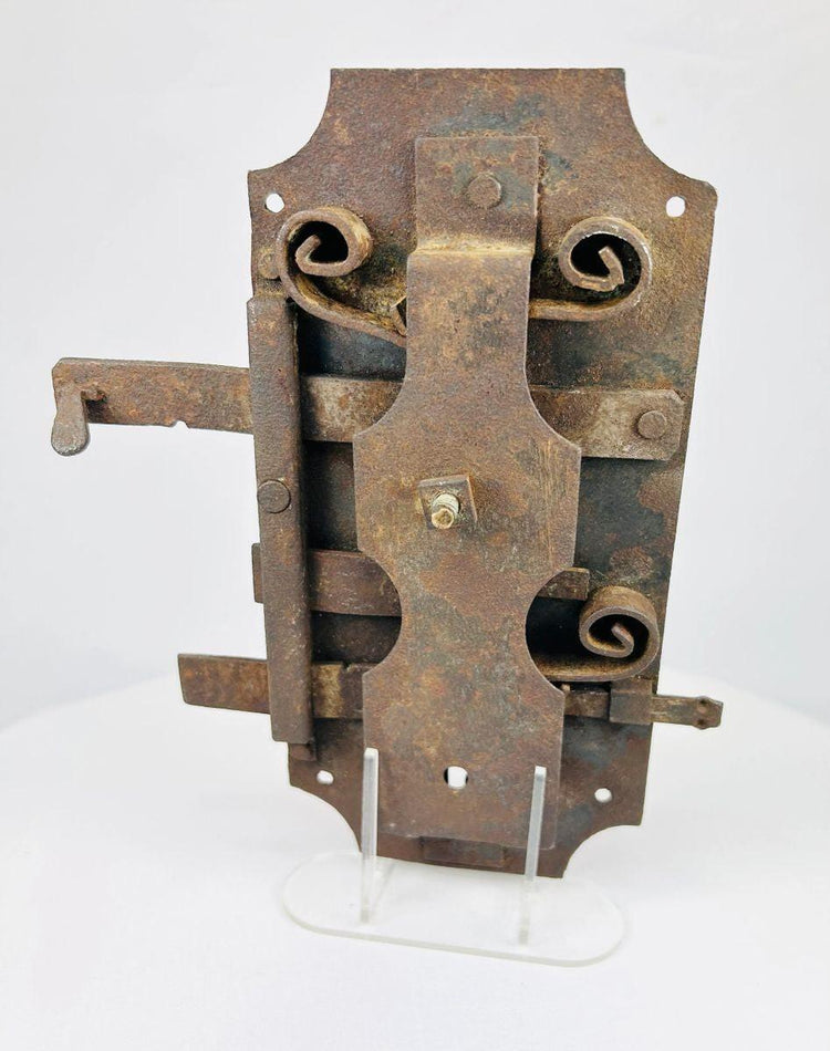 Antique forged iron door lock with visible internal mechanism and scroll springs