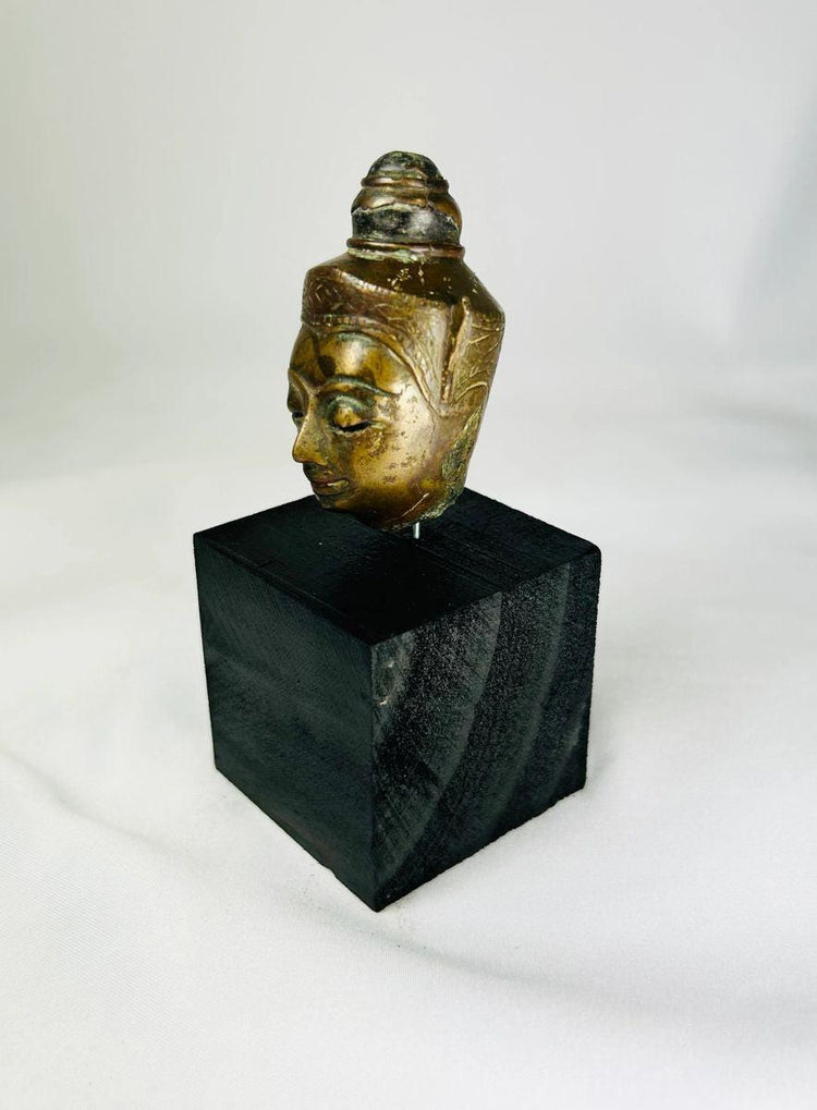 Southeast Asian 18th–19th century bronze Buddha head with pointed ushnisha and natural green patina on black display base