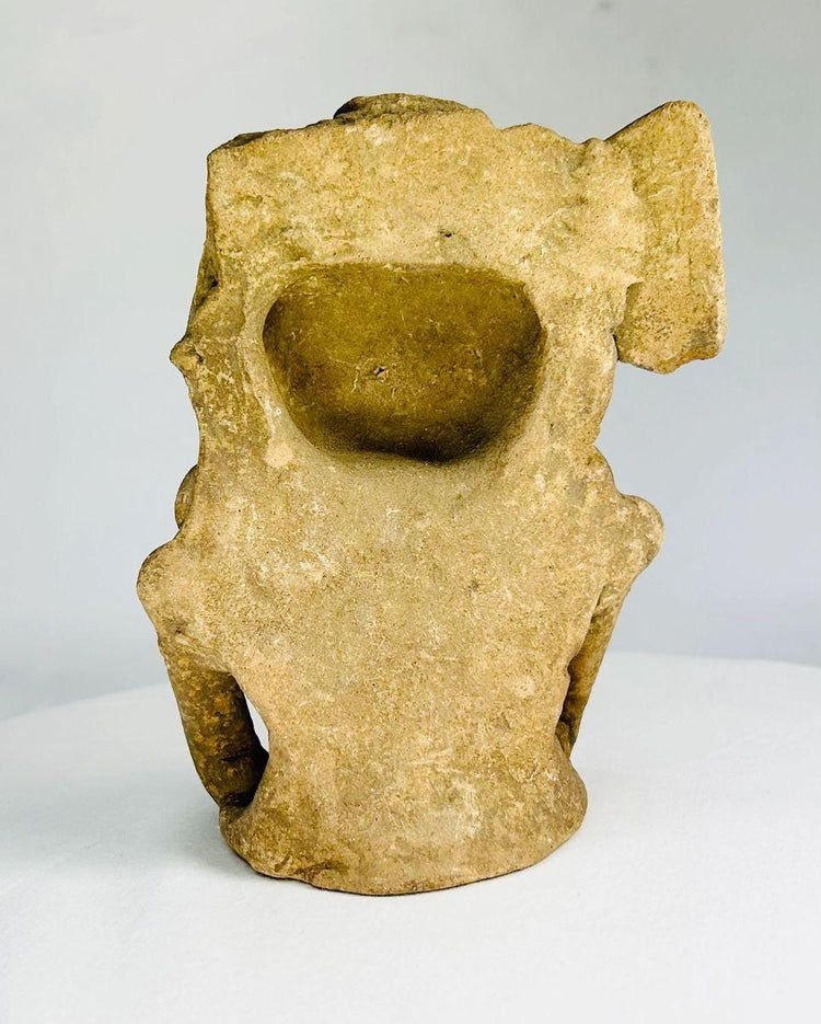 Seated pre-Columbian ceramic figurine from Mesoamerica featuring serene facial expression, bent-knee posture, and ceremonial headdress