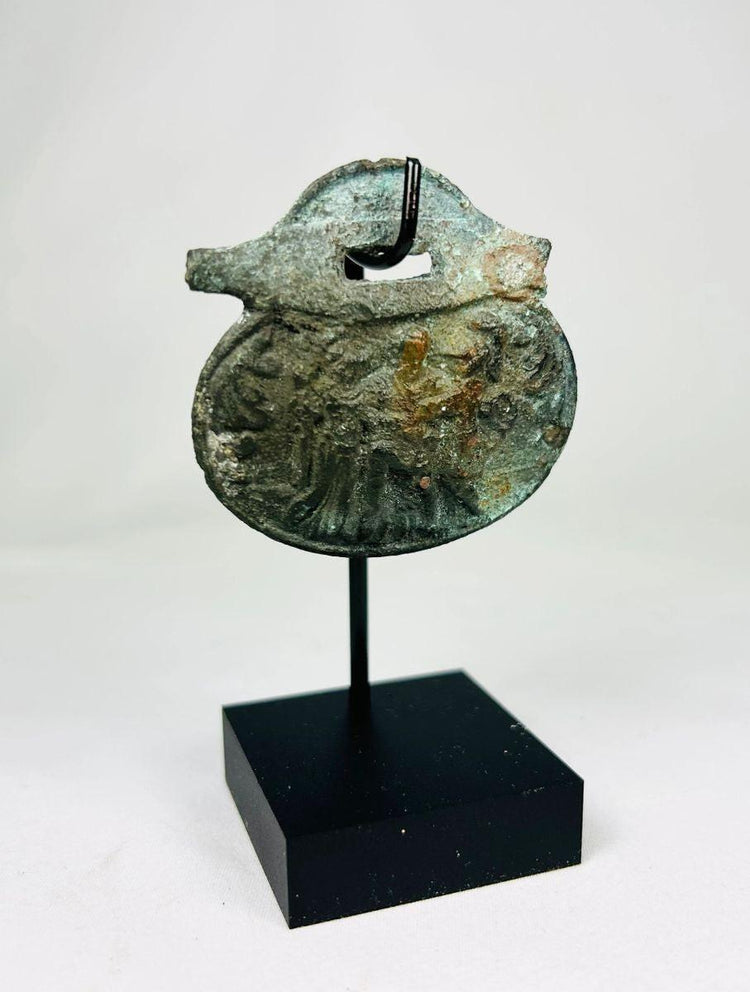 Full artifact image of ancient Roman bronze pendant with helmeted soldier iconography.