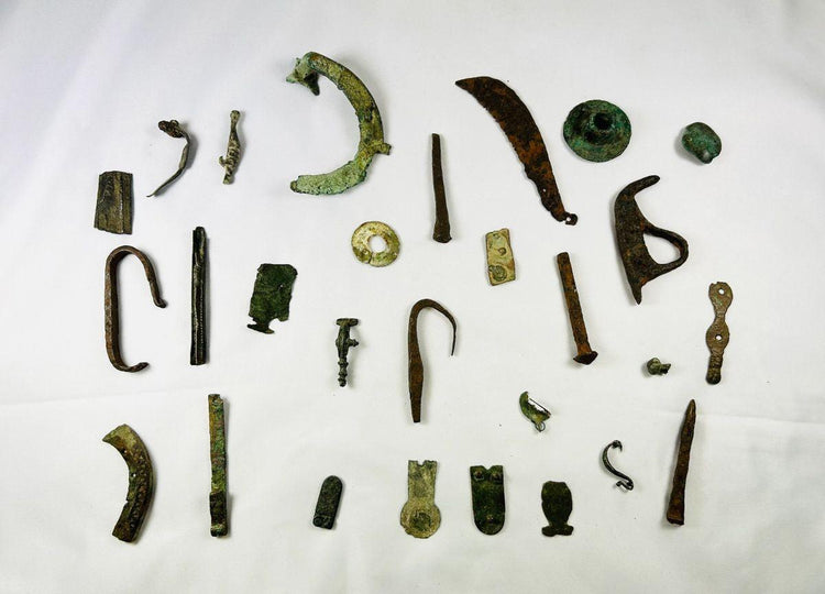 Collection of mixed Roman bronze relics displayed on a black background, featuring symbolic and utilitarian items