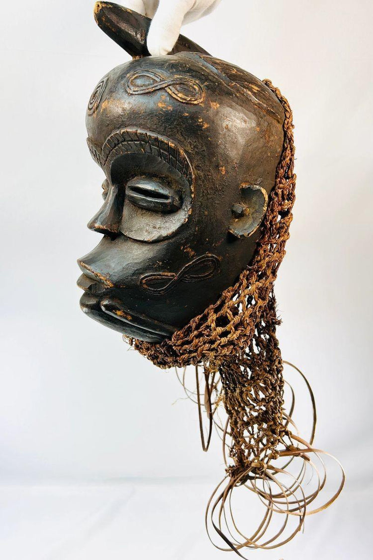 African Chokwe mask with serene closed eyes and geometric forehead motifs