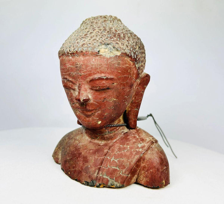 Close-up of antique wooden Buddha face showing serene expression and finely carved features.