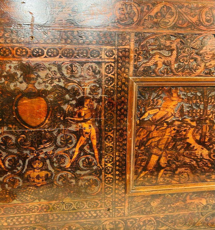 Close-up of 16th-century Renaissance carved wood panel featuring a heraldic shield, mythological figure, and ornate scrollwork.