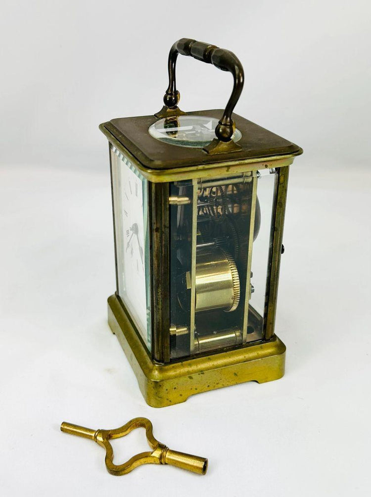 Detailed macro photo of brass frame and Roman numeral dial from a 19th-century French clock.