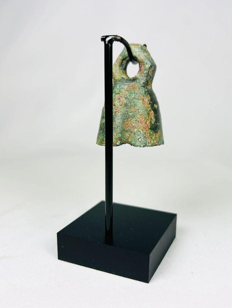 Angled view of ancient cast bronze Roman bell showing natural patina and metalwork.