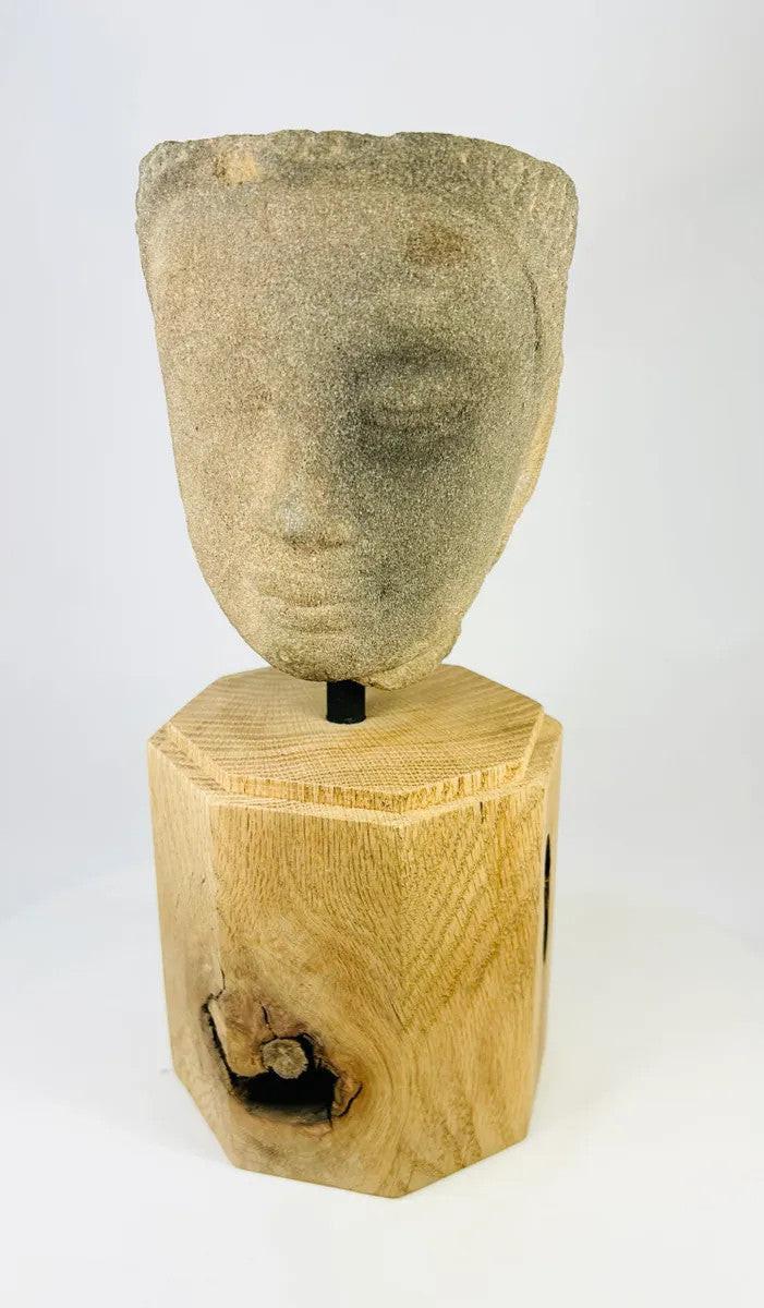 Frontal view of Khmer Sandstone Buddha Head Fragment from 12th-Century Angkor Period Cambodia, depicting serene facial expression and fine sandstone detail on wooden display base – Relic and Rarity.