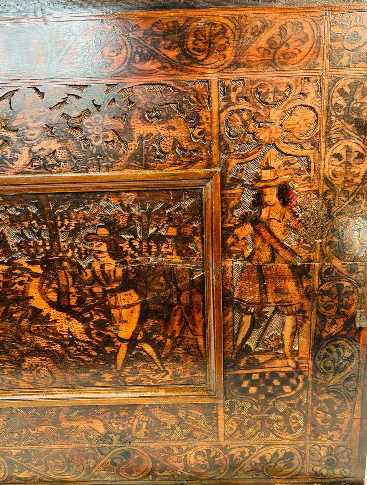 Detailed hunting scene carved in hardwood during the Renaissance, with human figures, animals, and ornate framing.