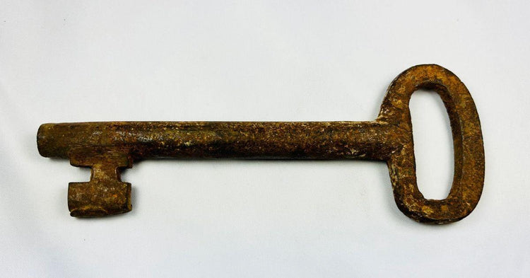 Antique forged iron skeleton key from 18th-century Europe, showing detailed ward and corroded patina, authentic historical artifact.