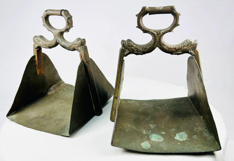 Heavy antique stirrups featuring detailed craftsmanship and natural patina