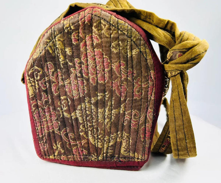 Silver repoussé Tibetan gau shrine housed in traditional embroidered fabric bag