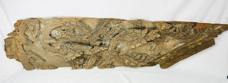 Antique Thai wooden temple carving with symmetrical sacred patterns