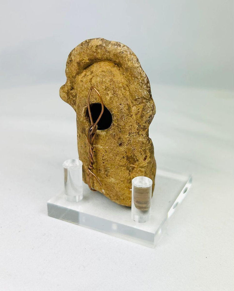 Close-up of ancient terracotta face with finely modeled eyes, nose, and lips.