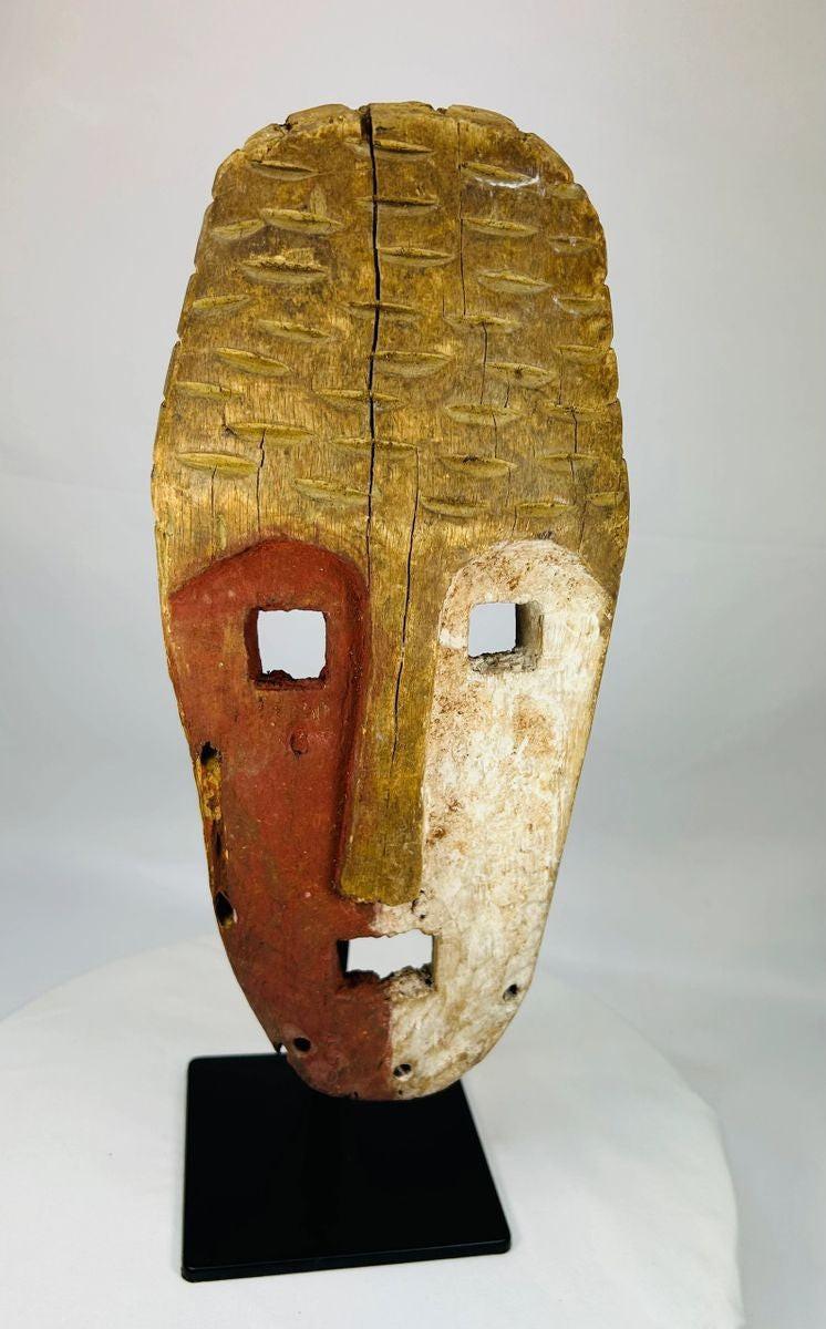 Hand-carved Sepik River mask with red ochre and lime pigments