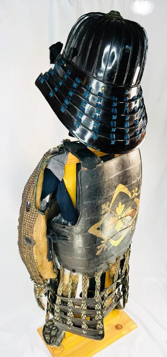 Left rear angle of authentic Muromachi Samurai armor (1333–1573) showing lacquered back plates, silk odoshi lacing, and iron arm guards.