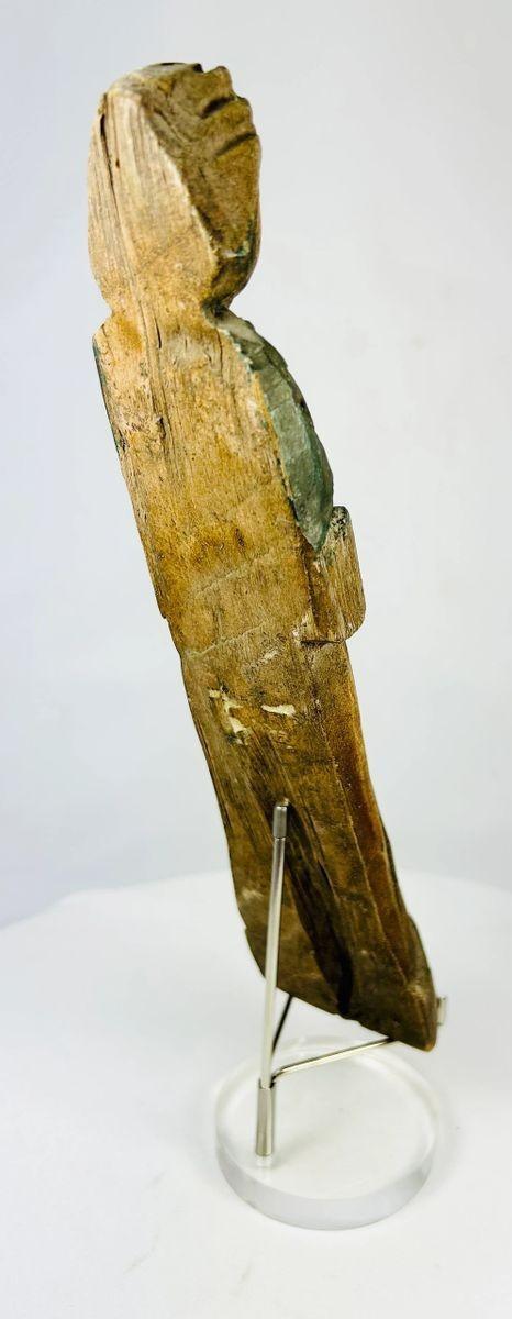 Hand-carved wooden devotional figurine showing aged surface and remnants of green pigment.