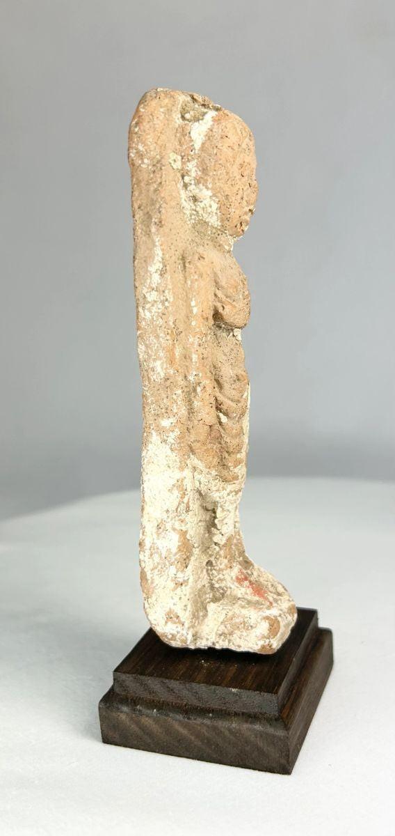 Terracotta female fertility idol from the Levant displayed on wood stand.