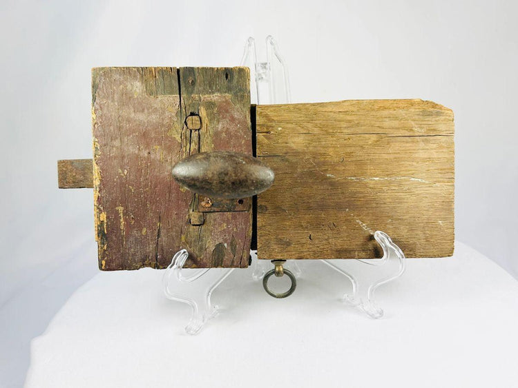 Colonial-era wooden locking mechanism with decorative forged iron backplate