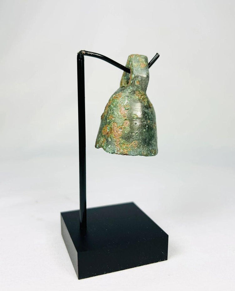 Side view of ancient Roman ritual bell highlighting its rounded body and cast bronze construction.