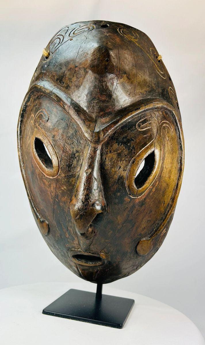 Macro view highlighting wood grain and carved texture on a Sepik River mask