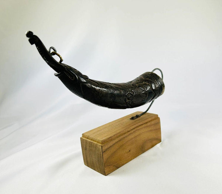 Antique Himalayan ritual horn dispenser displayed on a wood base.