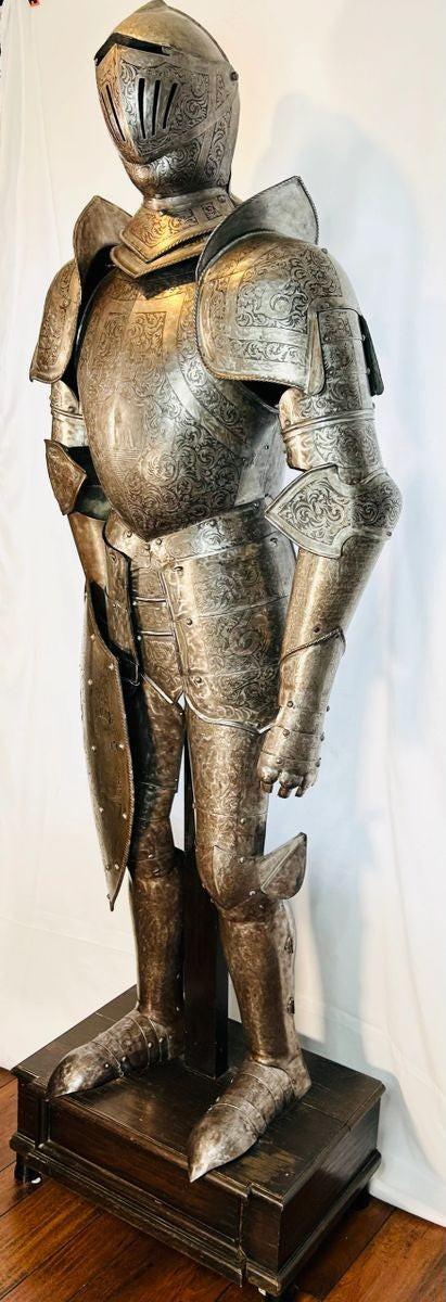 19th-century armor with intricate engravings of dragons, crowns, and battle scenes