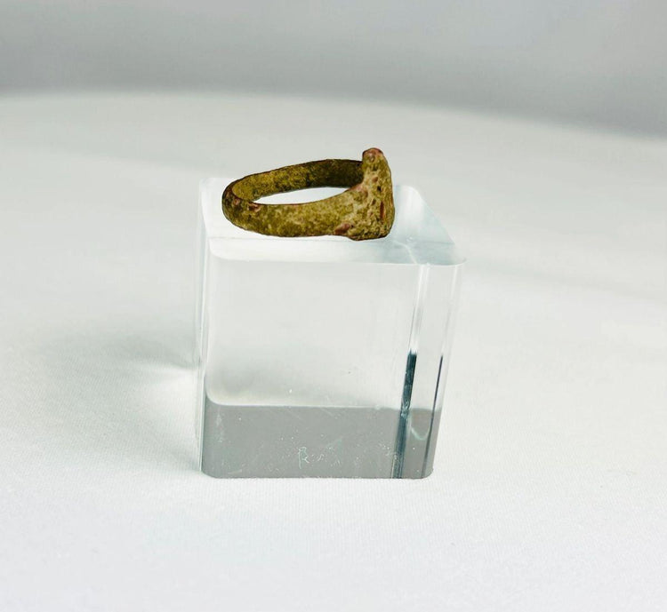 Side view of an ancient bronze ring highlighting thickness and worn surface from centuries of use
