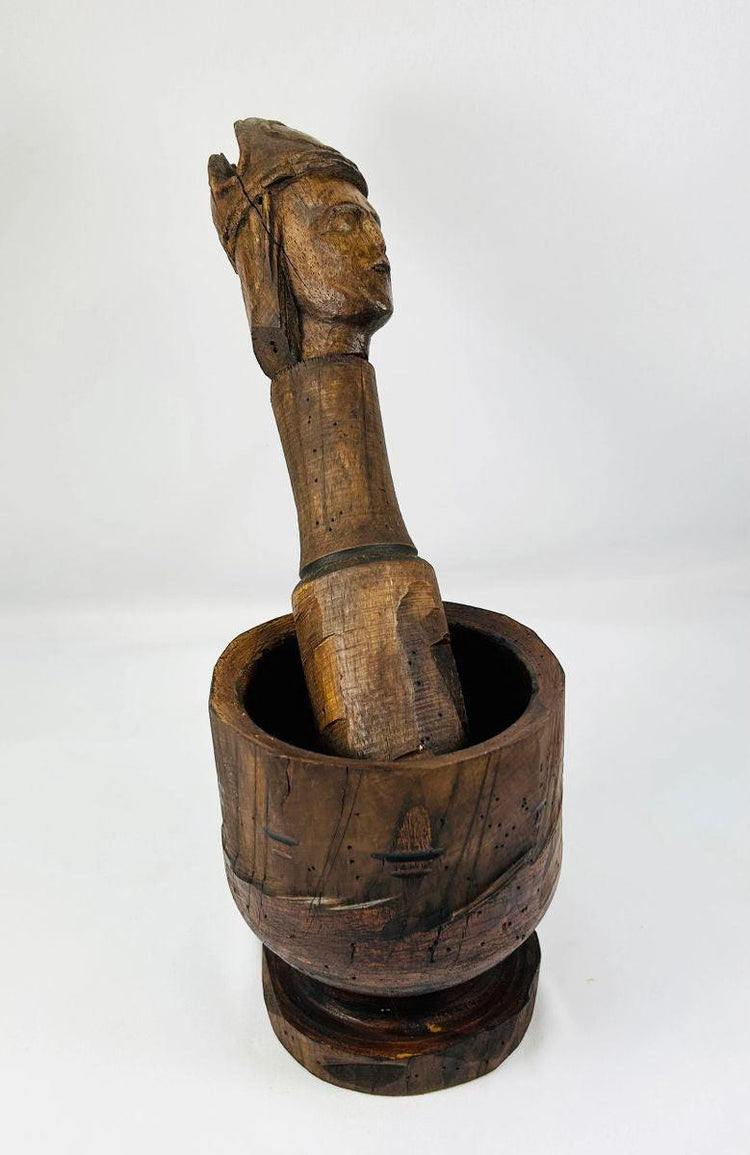 Finely carved wooden pestle paired with robust European mortar
