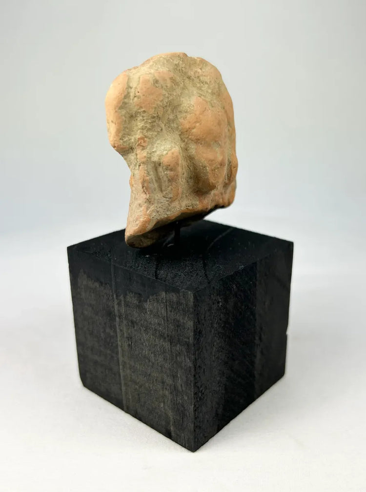 Gandharan terracotta fragment with central male figure and faint side images