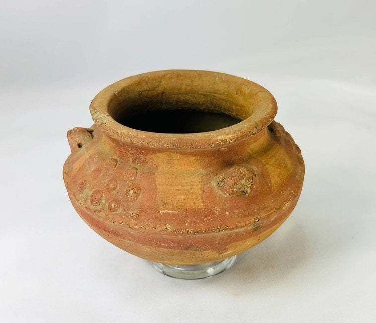 Hand-molded terracotta vessel featuring sculpted motifs and ceremonial use