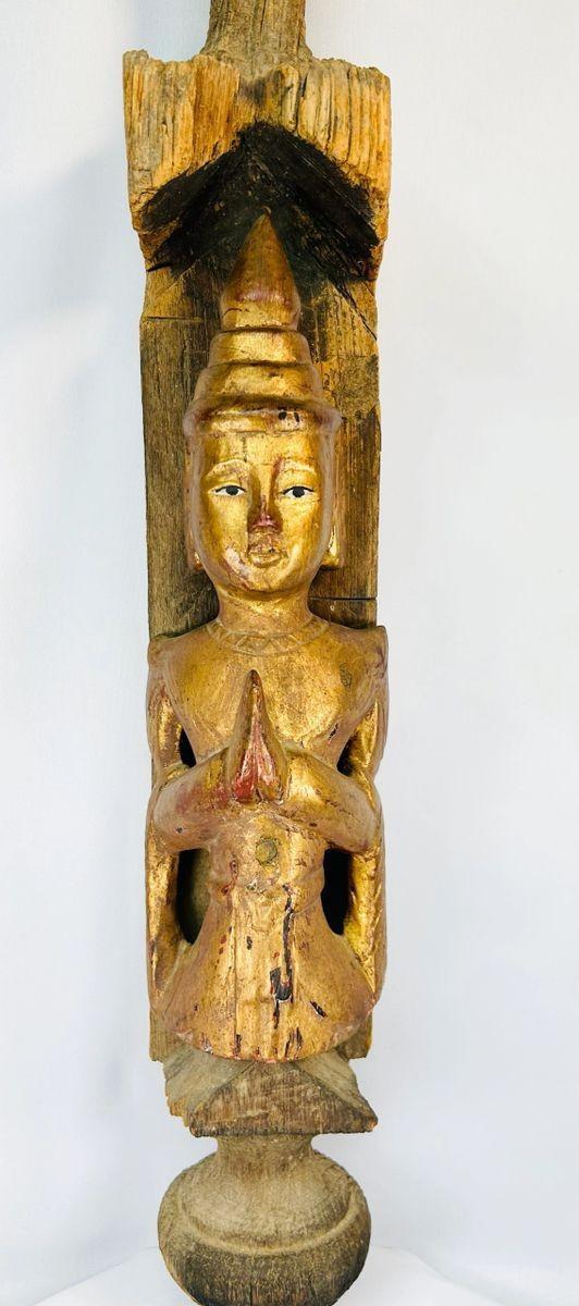 Museum-style display of an antique Burmese Buddhist temple finial with gilded figure