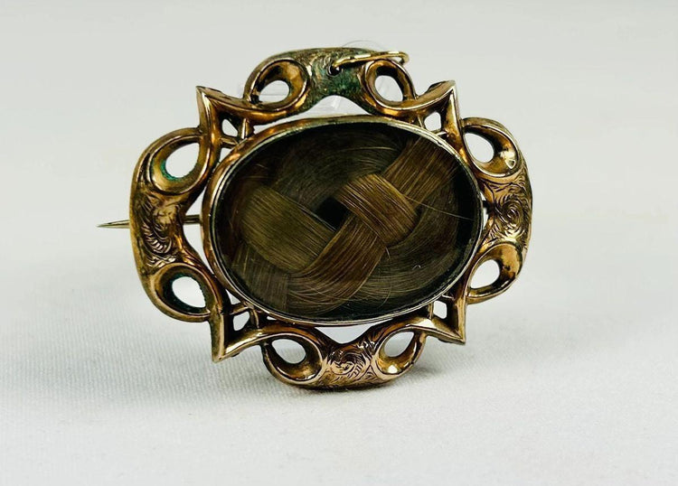 Close-up of aged patina on a gold-plated Victorian mourning brooch frame.