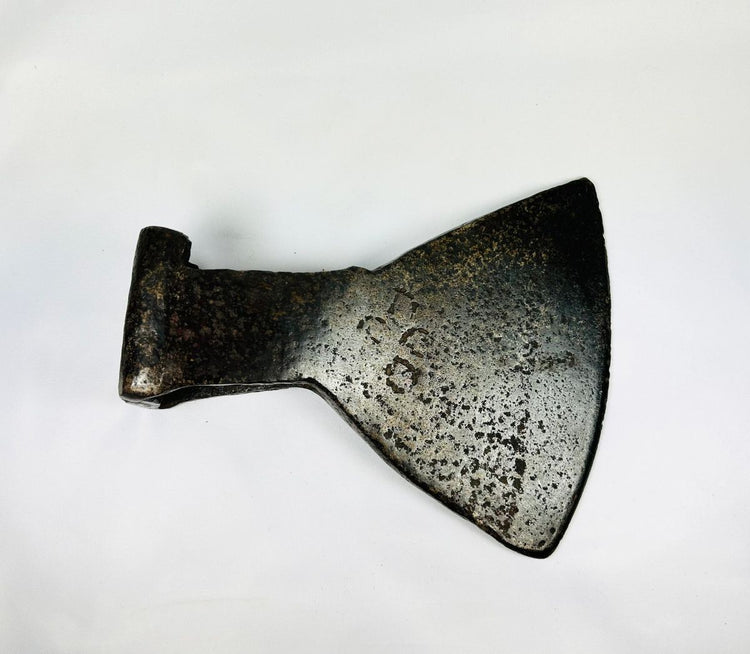 Historic cast iron axe head with triangular socket and oxidation details.