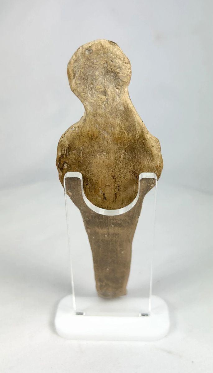 Rear view of ancient terracotta fertility figure with surface patina and age-related wear.