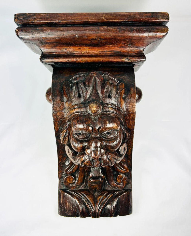 Antique hand-carved wooden corbel with grotesque face and historic craftsmanship