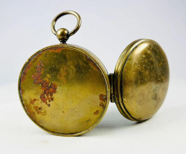 Close-up photograph of aged patina and machining marks on a French brass pocket compass.