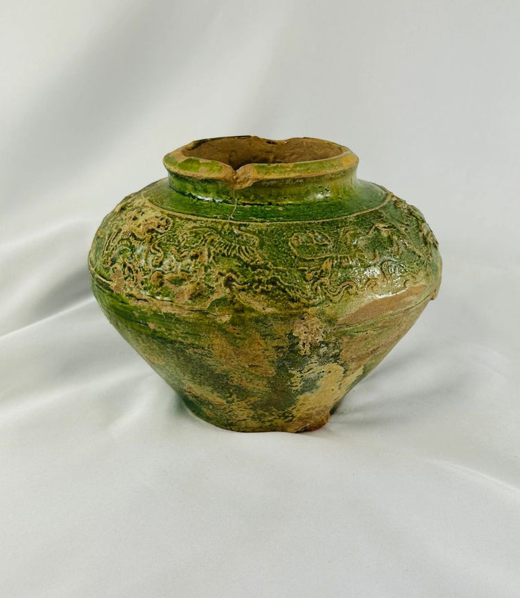 Close-up of green-glazed Chinese pottery jar showing relief designs from the Han Dynasty.