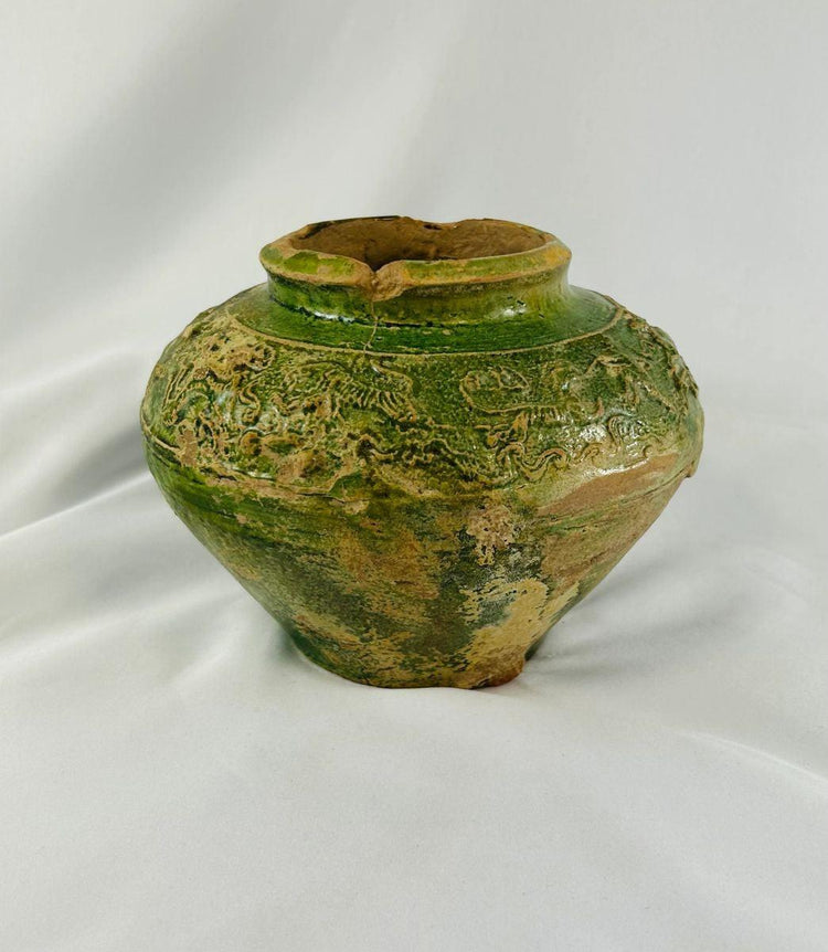Close-up of green-glazed Chinese pottery jar showing relief designs from the Han Dynasty.