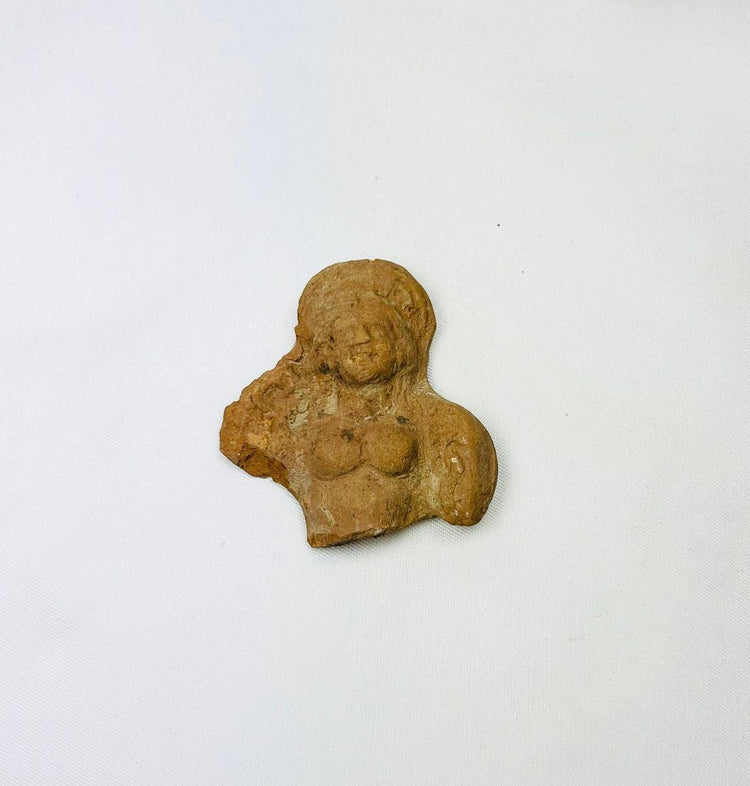 Close-up photo of a Ptolemaic terracotta female torso fragment showing preserved facial features.