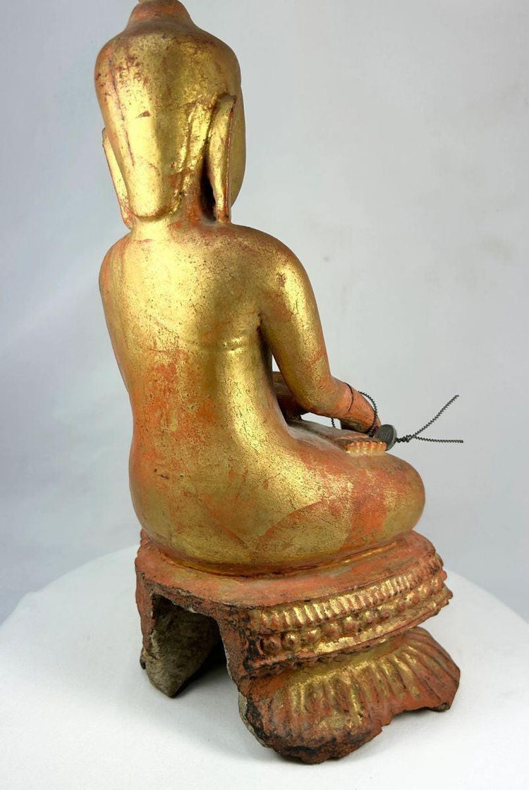 Back view of an antique Burmese monk statue with aged lacquer surface