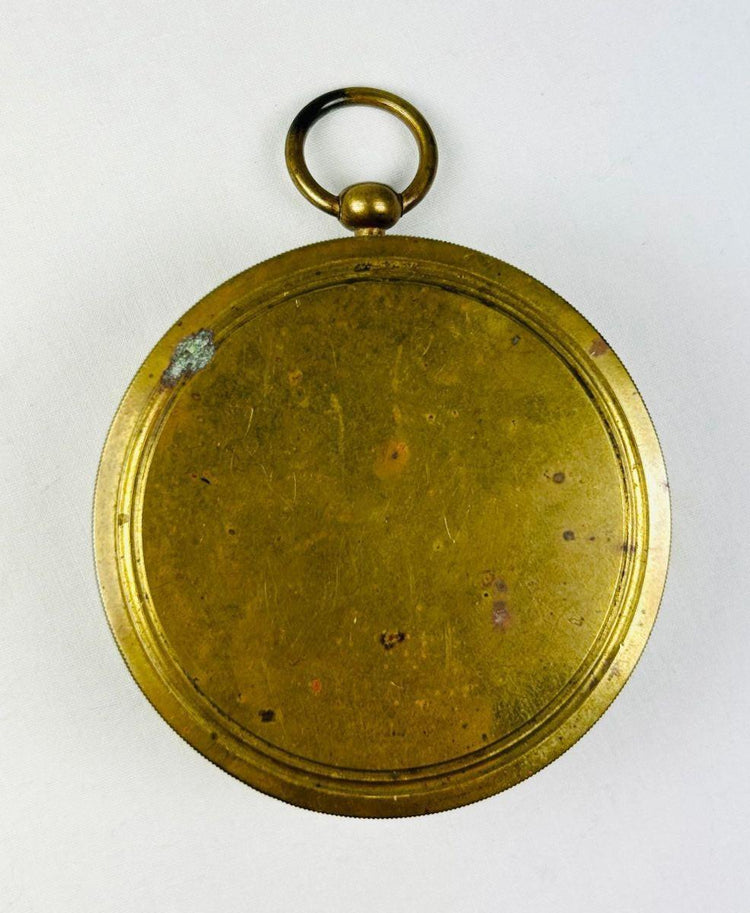 Back view of a French pocket compass showing smooth brass casing and natural age patina.