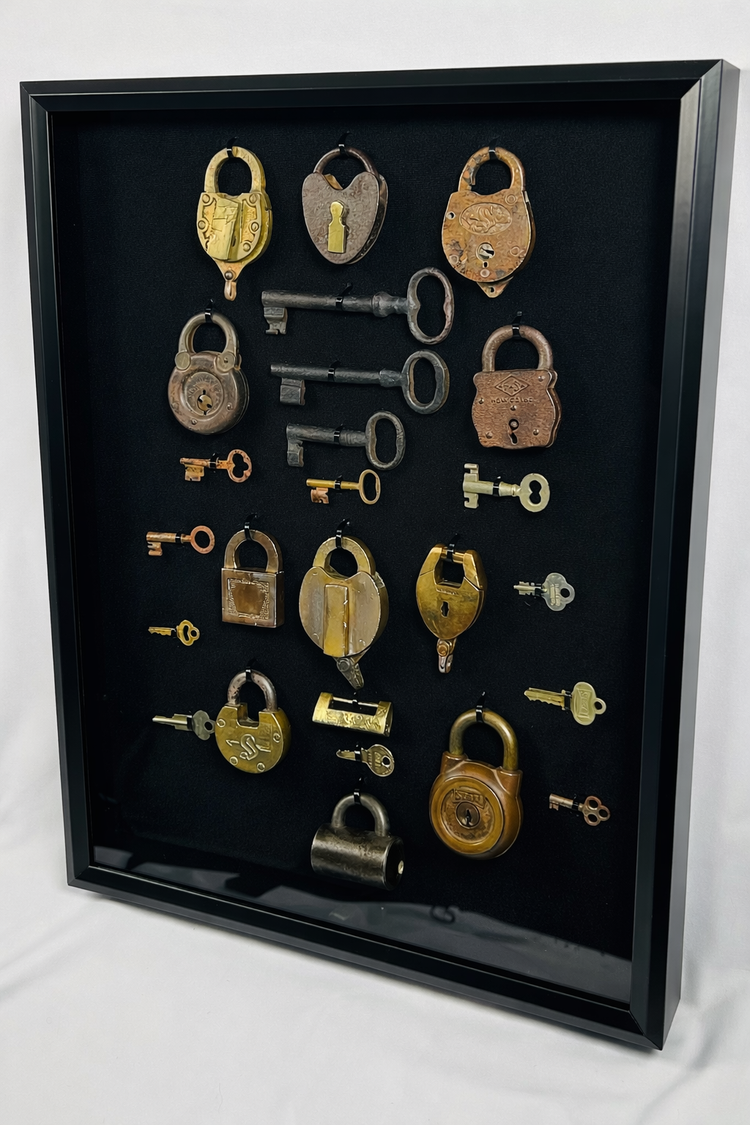 Vintage padlock collection with brass and iron locks arranged in a shadow box frame