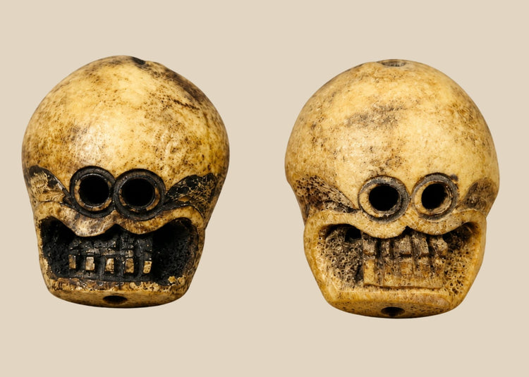 Pair of 18th-century Tibetan Kapala Citipati beads carved from human femur bone with skull motifs and suspension holes