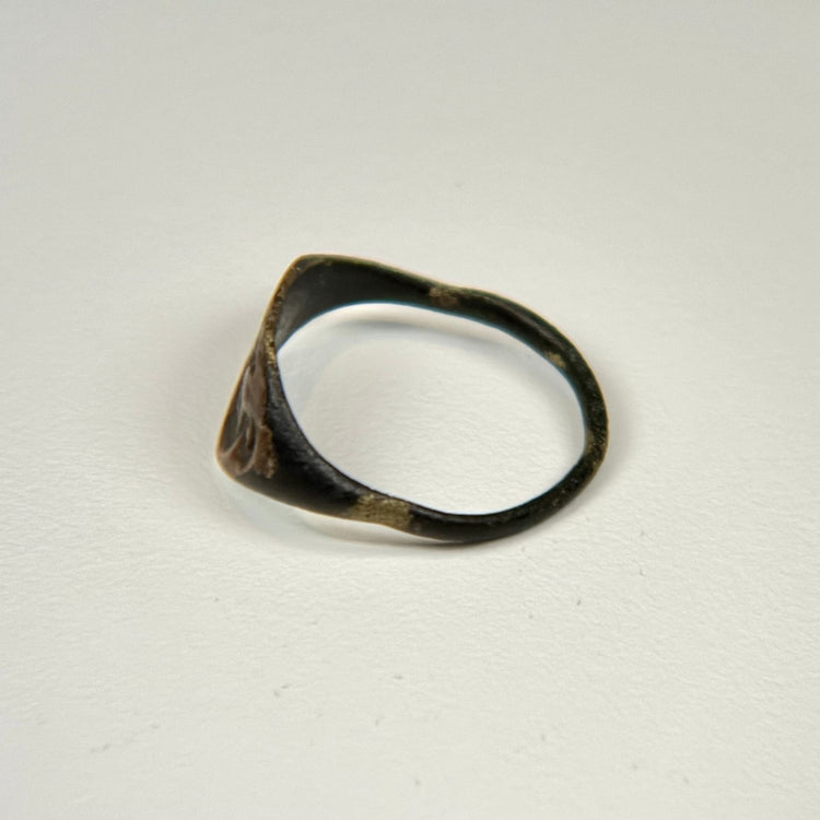 Ancient bronze signet-style ring displaying a horned bull motif on an oval bezel