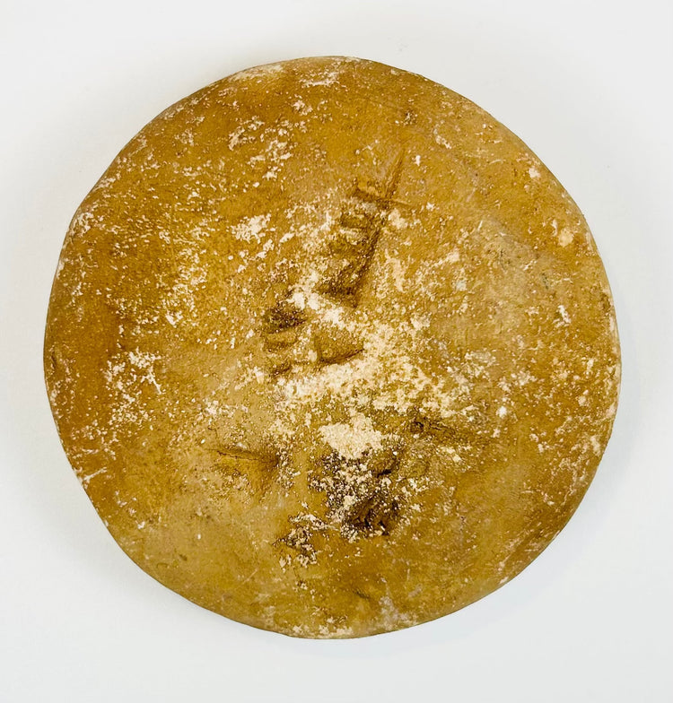 Handheld ancient seal with circular form and symbolic design