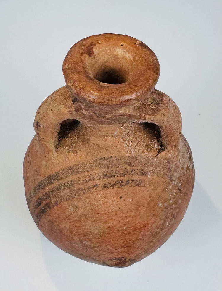 Close-up of black painted decoration on an orange-red Cypriot ceramic surface